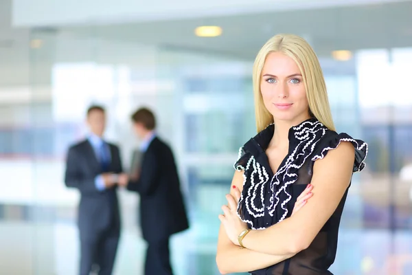 Business woman standing in foreground  in office