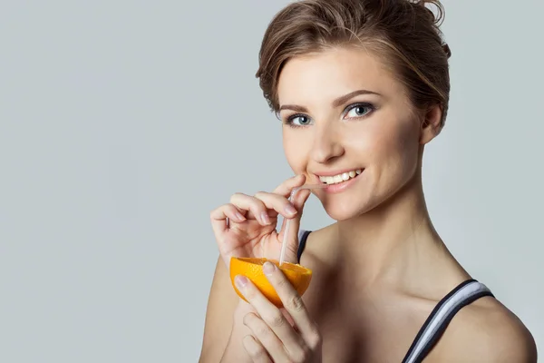 Beautiful young athletic girl energetic happy drinking orange juice, healthy lifestyle