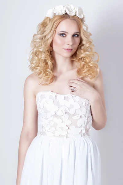 Beautiful lovely gentle elegant young blond woman in a white sundress chiffon and curls, and a wreath of flowers in her hair