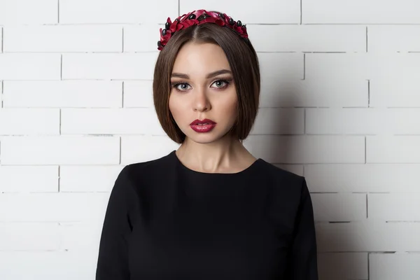 Elegant beautiful sexy woman in evening dress with a bright evening make-up with full lips with red lipstick on her lips , and with a wreath of olive branches on her head