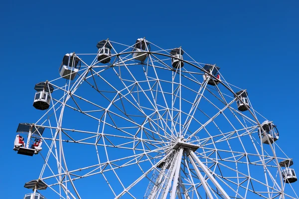 Ferris wheel against bright blue sky