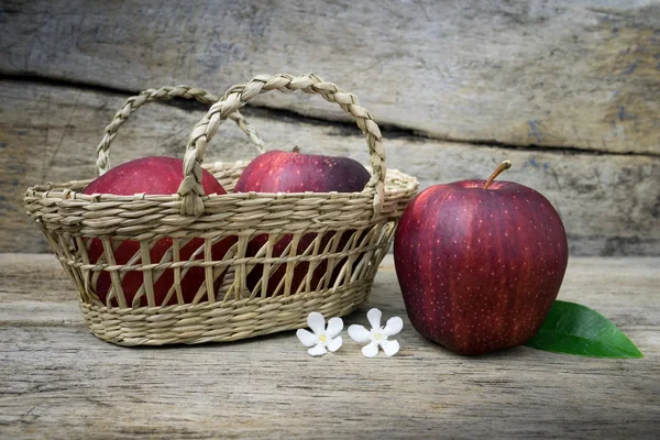 Basket with apples on grunge wooden background