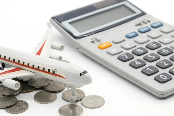 Calculator and toy plane on white background