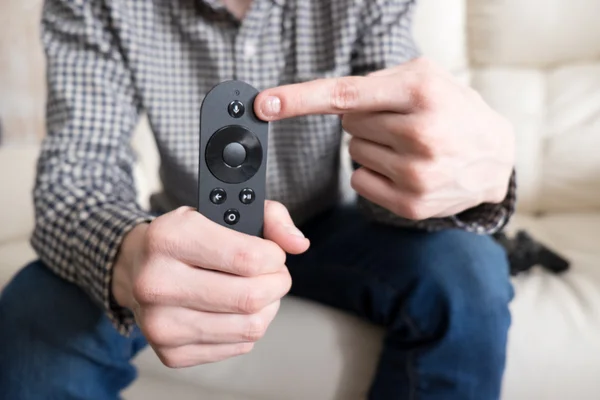 Man is  holding remote controller