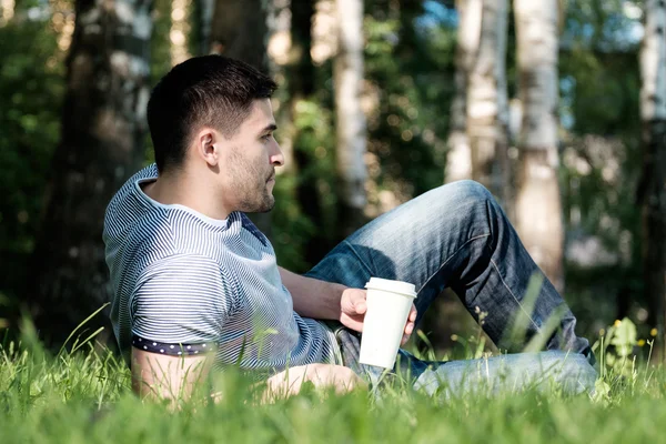 Man with coffee in park