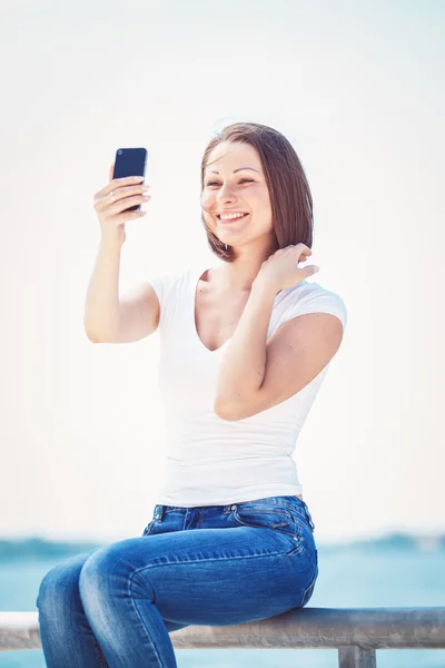 Girl woman looking at cell phone making selfie