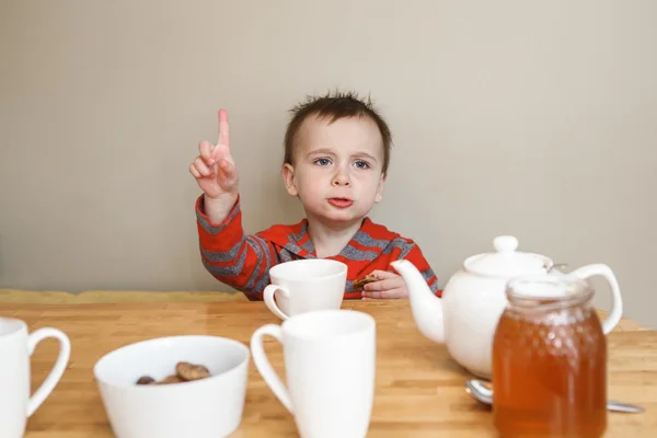 Cute funny boy toddler at table in kitchen