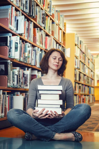 Portrait of tired middle age mature woman student sitting in library with closed eyes meditating, sleeping, teacher librarian profession, back to school concept