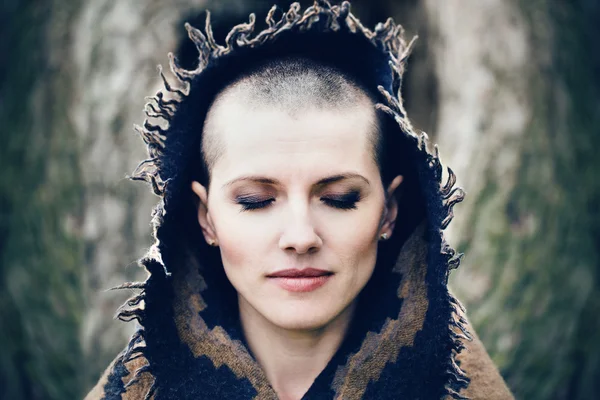 Closeup portrait of beautiful Caucasian white young bald girl woman with shaved hair head with closed eyes, her head covered with scarf shawl, spiritual mood state of mind