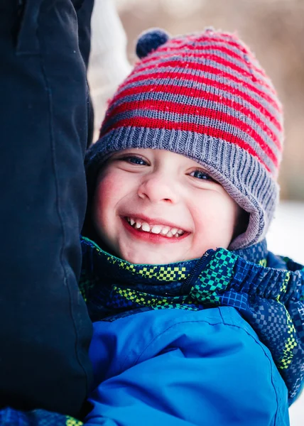 Closeup portrait of smiling laughing Caucasian white toddler boy child in winter clothes hugging his mother parent outside, winter fun, lifestyle concept, beautiful smile, natural emotional face xpression
