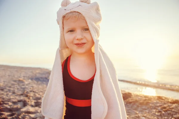 Portrait of cute adorable happy smiling toddler little girl with towel on beach making poses faces having fun, emotional face expression, lifestyle sunset summer mood, toned