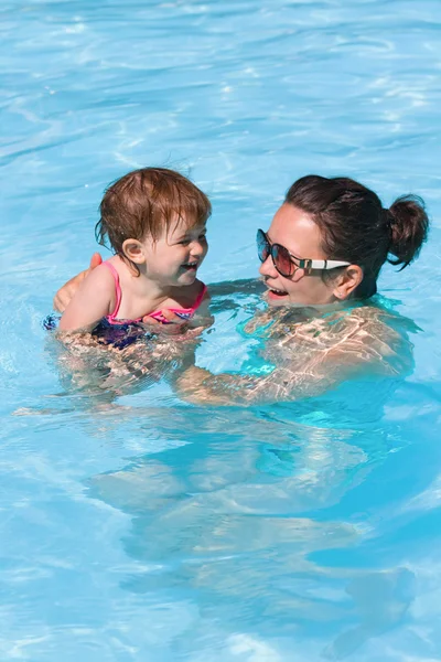 Family in swimming pool playing