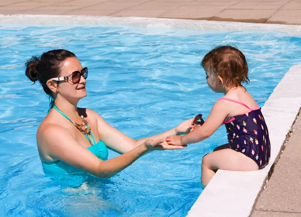 Family in swimming pool playing