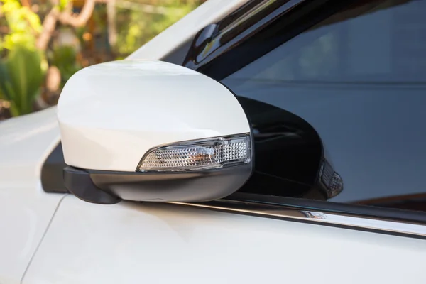 Modern white car side view mirror folded with turn signal
