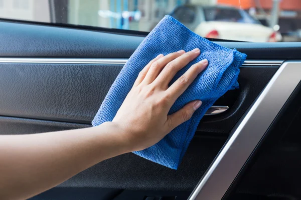 Hand with microfiber cloth cleaning Interior modern car.