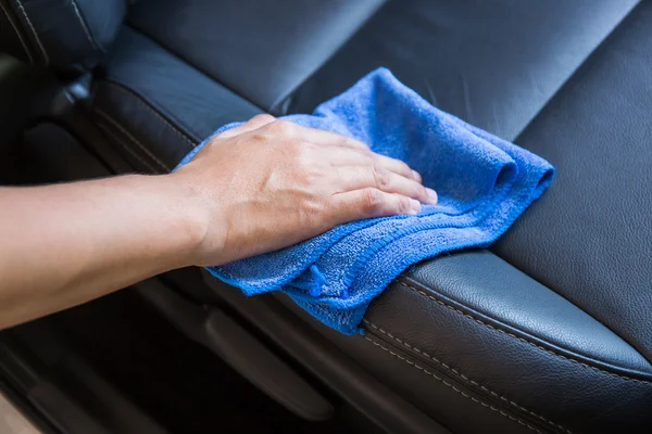 Hand with microfiber cloth cleaning Interior modern car.