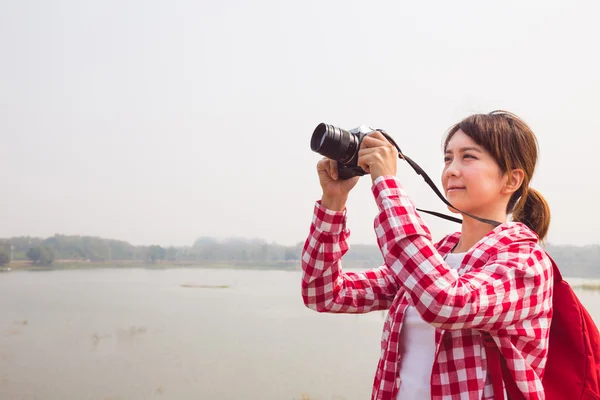 Young woman girl is travel with backpack and handle camera of take photos. travel concept