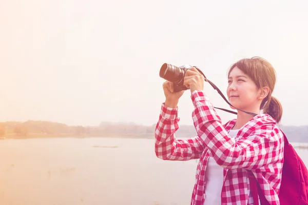 Young woman girl is travel with backpack and handle camera of take photos in pastel or vintage style color. travel concept copy space background