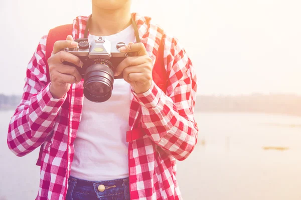 Young woman girl is travel with backpack and handle camera and check photos in pastel or vintage style color. travel concept copy space backgroun