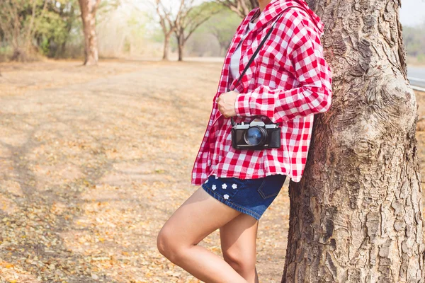 Tourist young woman holding vintage old photo camera in outdoor