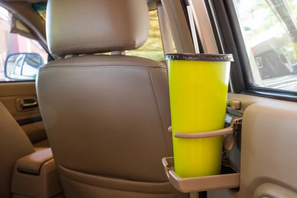 Coffee or tea mugs green placed on the vehicle console in modern luxury car interior
