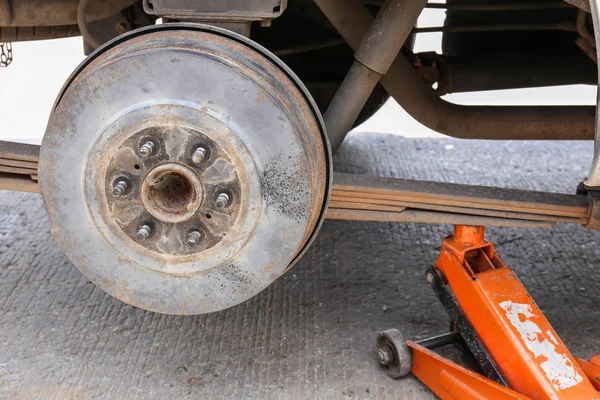 Remove wheel by car jack for repair with tool. selective focus orange car jack