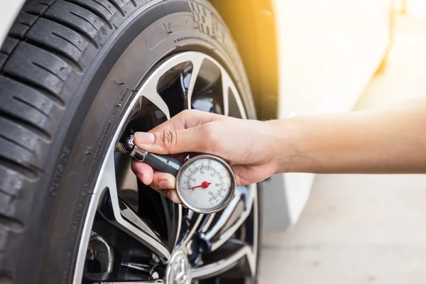 Close-Up Of Hand holding pressure gauge for car tyre pressure me