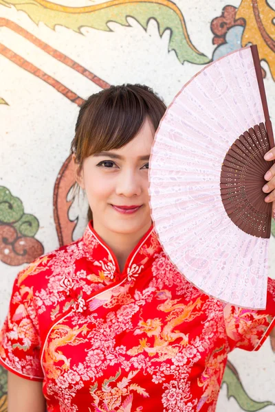 Beautiful Asian woman wearing traditional Cheongsam on chinese pattern traditional background