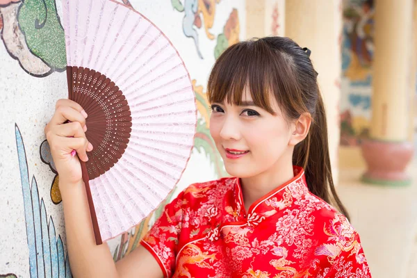 Beautiful Asian woman wearing traditional Cheongsam on chinese pattern traditional background