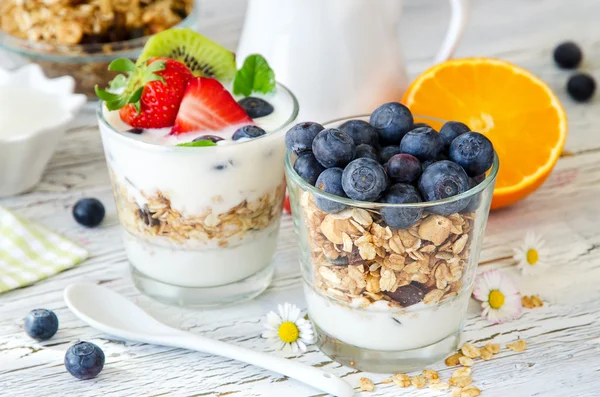 Healthy breakfast with muesli in glass, fresh berries and yogurt