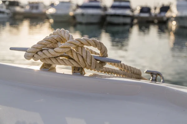 Close-up nautical knot rope tied around stake on boat or ship, boat mooring rope