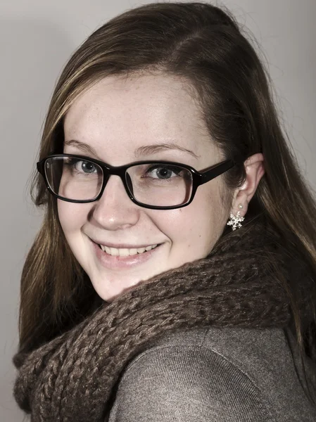 Studio portrait of beautiful young woman with blond hair, girl wearing glasses