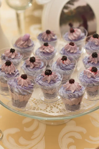 Candy Bar. Tray with delicious cakes. Elegant sweet table with big cake, cupcakes, cake pops on dinner or event party. Cake pops. Violet and White