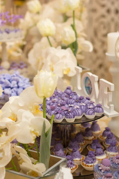 A candy buffet with a wide variety of candies, with white and violet colors