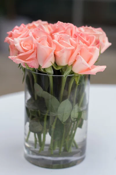 Beautiful flowers in vase. Bouquet of pink roses in a glass vase near the window, vertical photo.