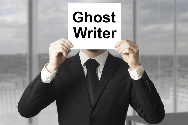 Businessman hiding face behind sign ghost writer