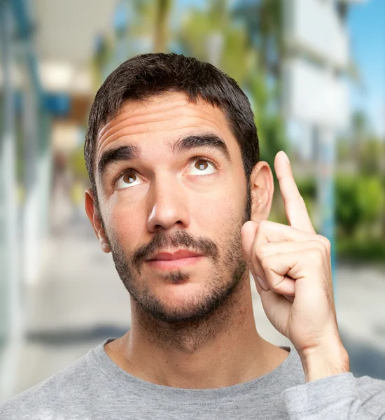 Close up of a young man pointing up