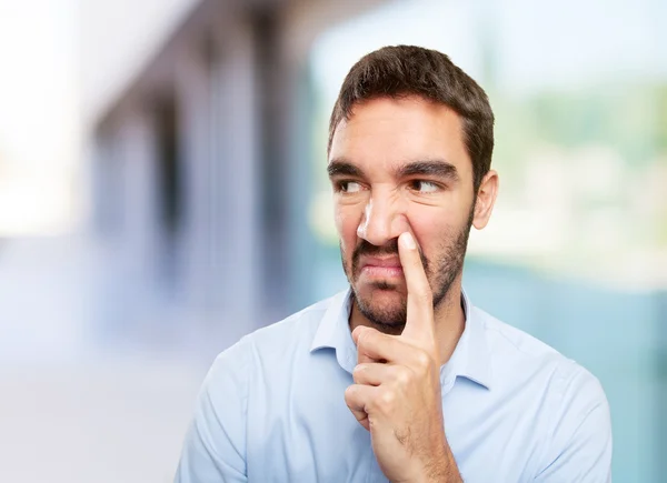 Close up of a young man with gesture of bad smell