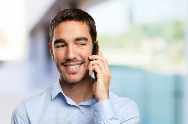 Close up of a happy young man calling on mobile phone