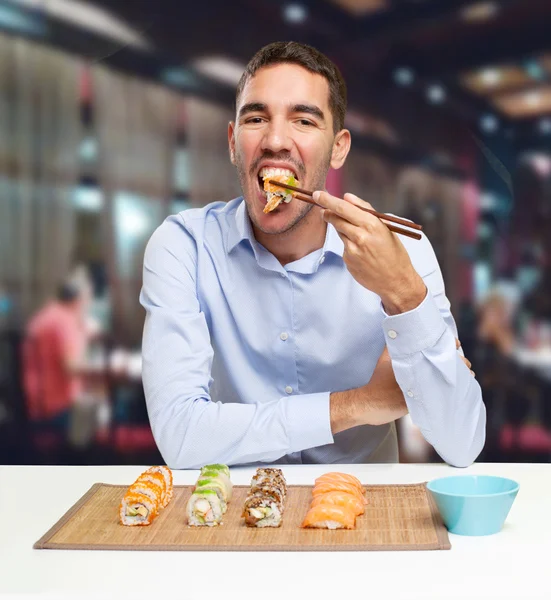 Young man eating sushi