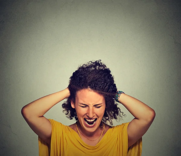 Stress. Woman stressed is going crazy pulling her hair in frustration