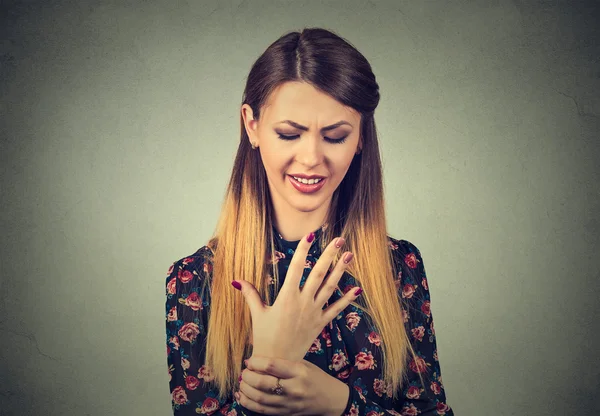 Woman holding her painful wrist