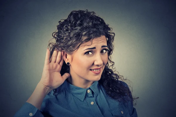 Unhappy hard of hearing woman placing hand on ear asking someone to speak up