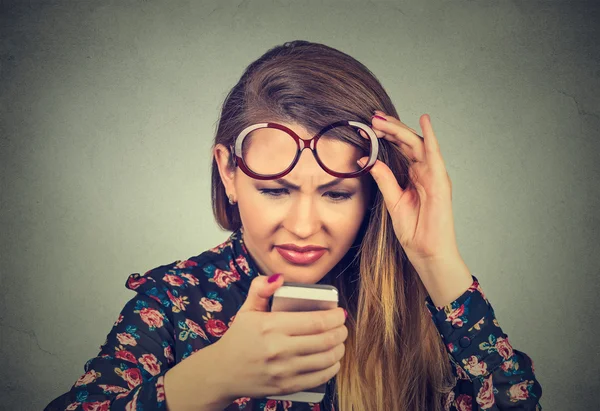 Headshot woman with glasses having trouble seeing cell phone has vision problems