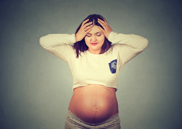 Portrait of a stressed young pregnant woman having headache