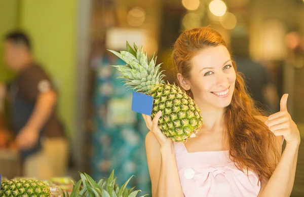 Happy young woman with pineapple smiling healthy and joyful in grocery shop