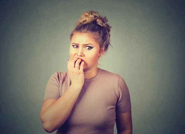 Nervous stressed young woman student biting fingernails looking anxiously craving