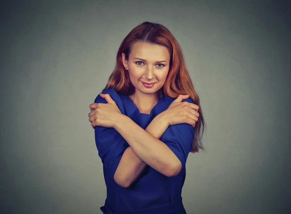 Confident smiling woman holding hugging herself