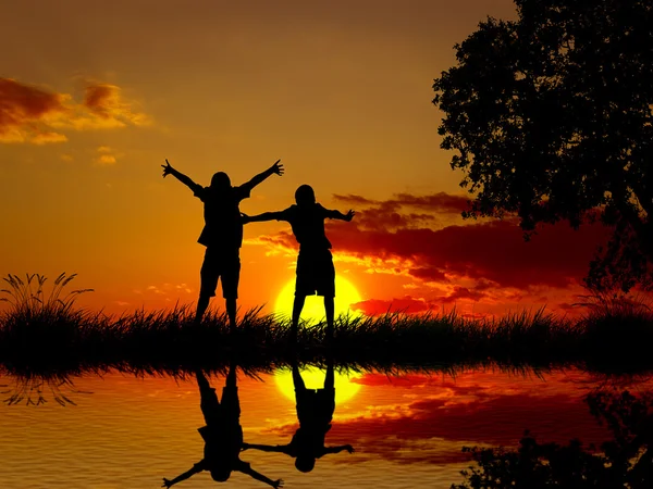 Silhouette happy excited carefree couple looking at sunset