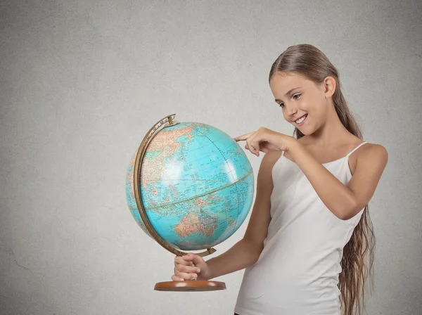 Teenager girl holding earth globe map deciding on her vacation trip